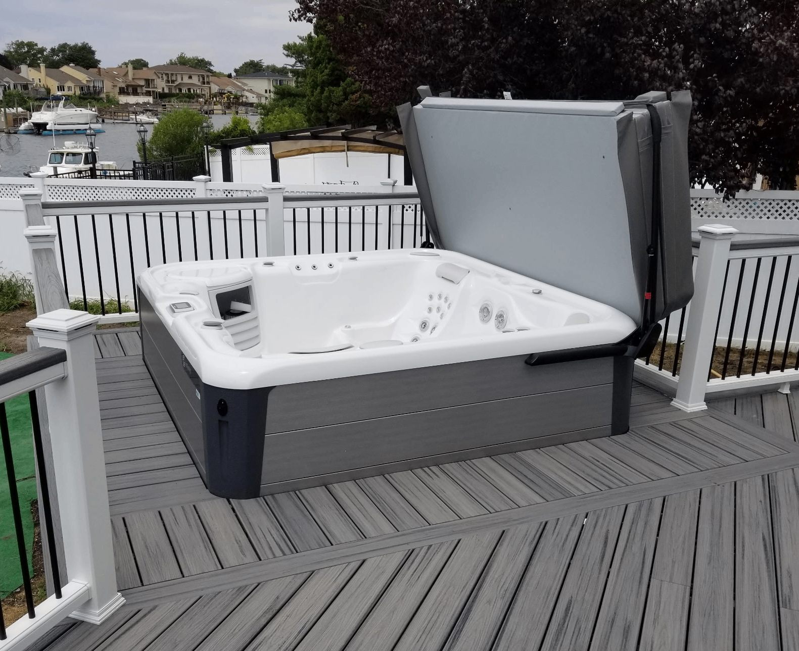 Waterfront deck with hot tub and grey composite decking